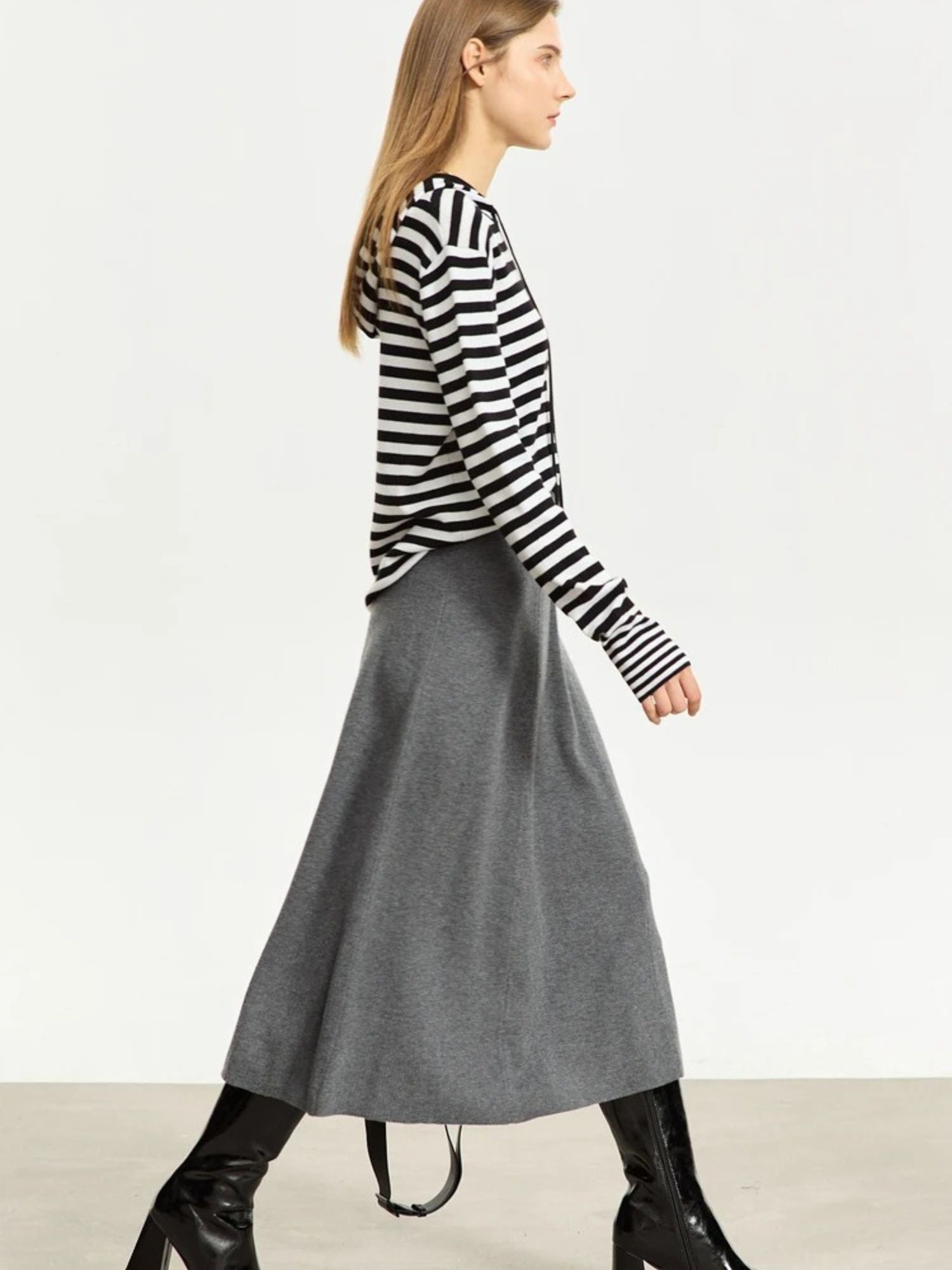Grauer A-Linien-Midirock aus Wolle, Modell gehend mit Streifenpullover.