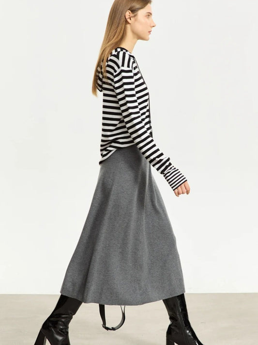 Grauer A-Linien-Midirock aus Wolle, Modell gehend mit Streifenpullover.