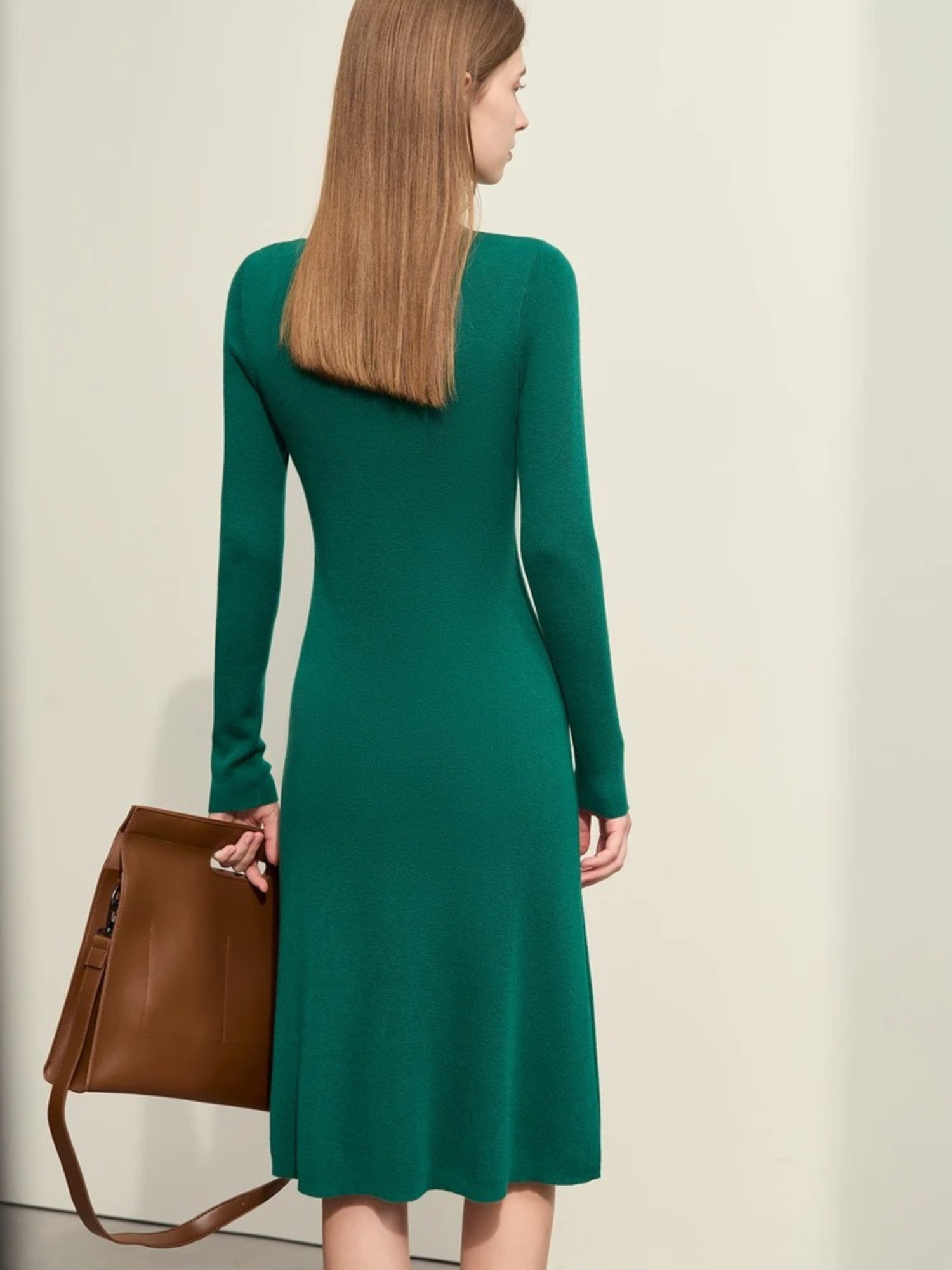 Grünes Strickkleid, Rückansicht des Modells mit Handtasche.