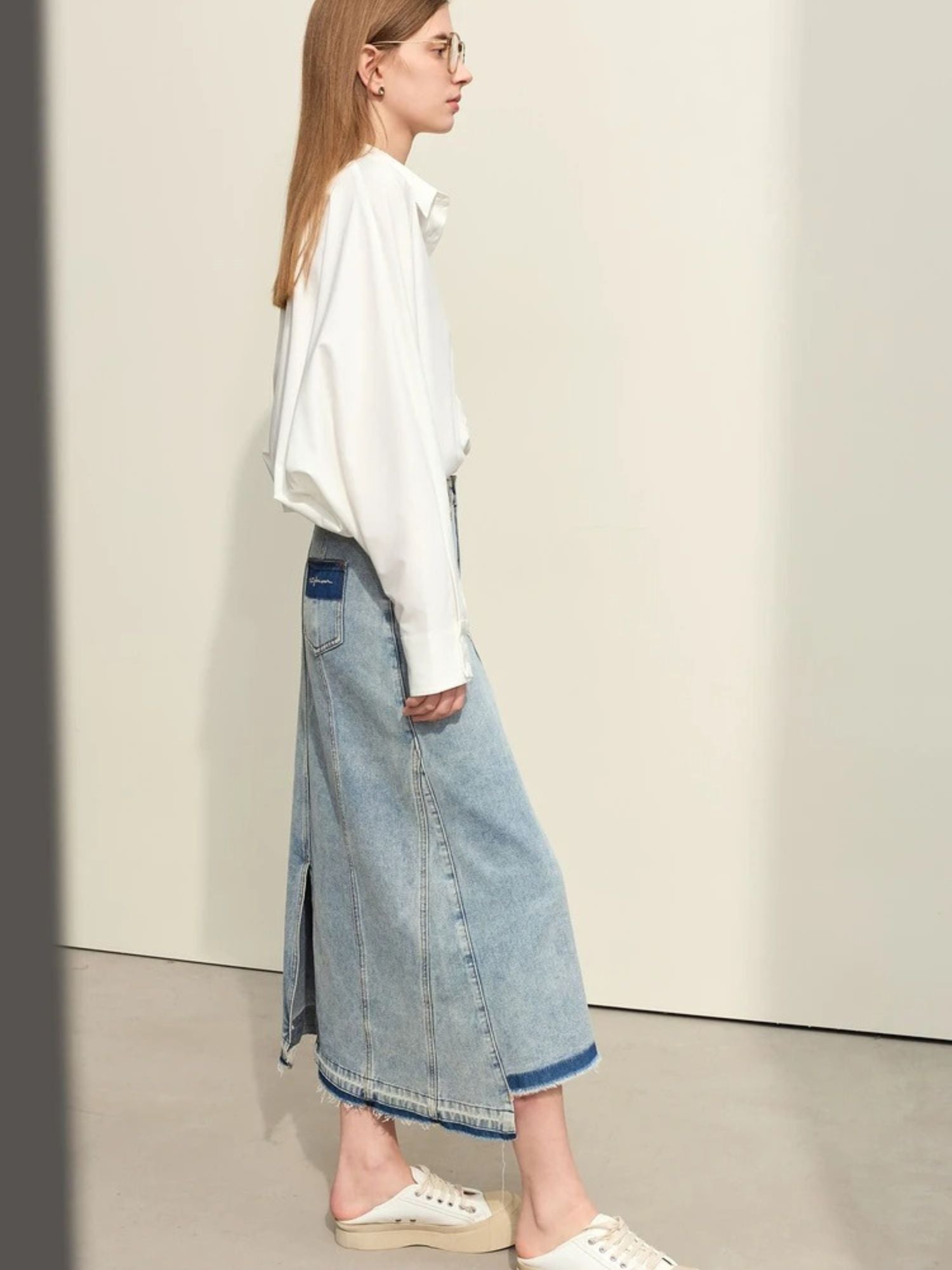 Jeans-Midirock mit Schlitz, seitliche Ansicht des Modells.