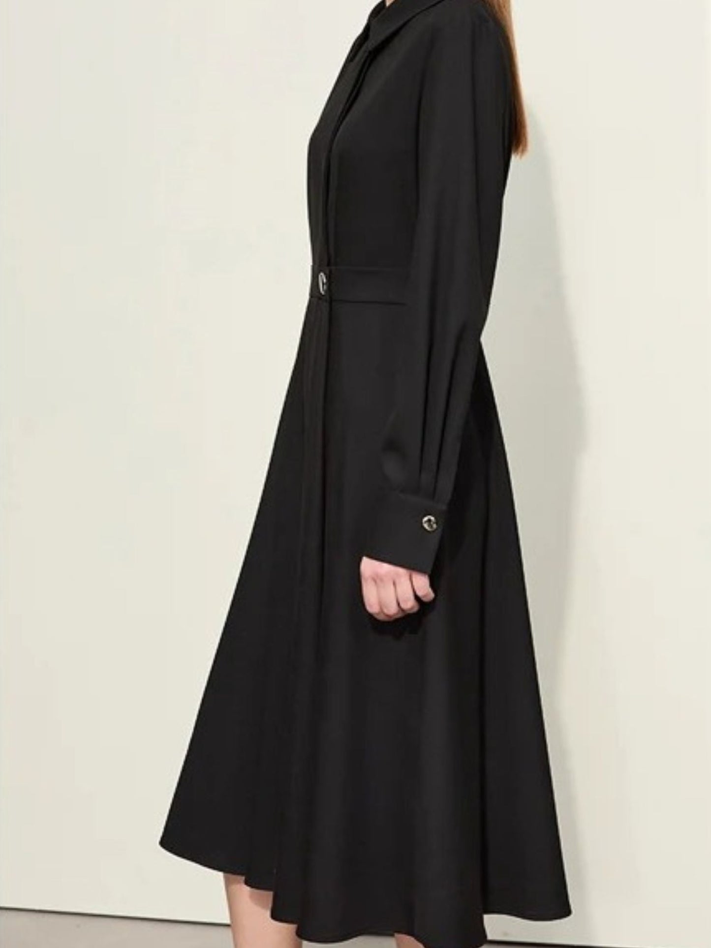 Schwarzes Midikleid mit Gürtel, Modell schräg von vorne.
