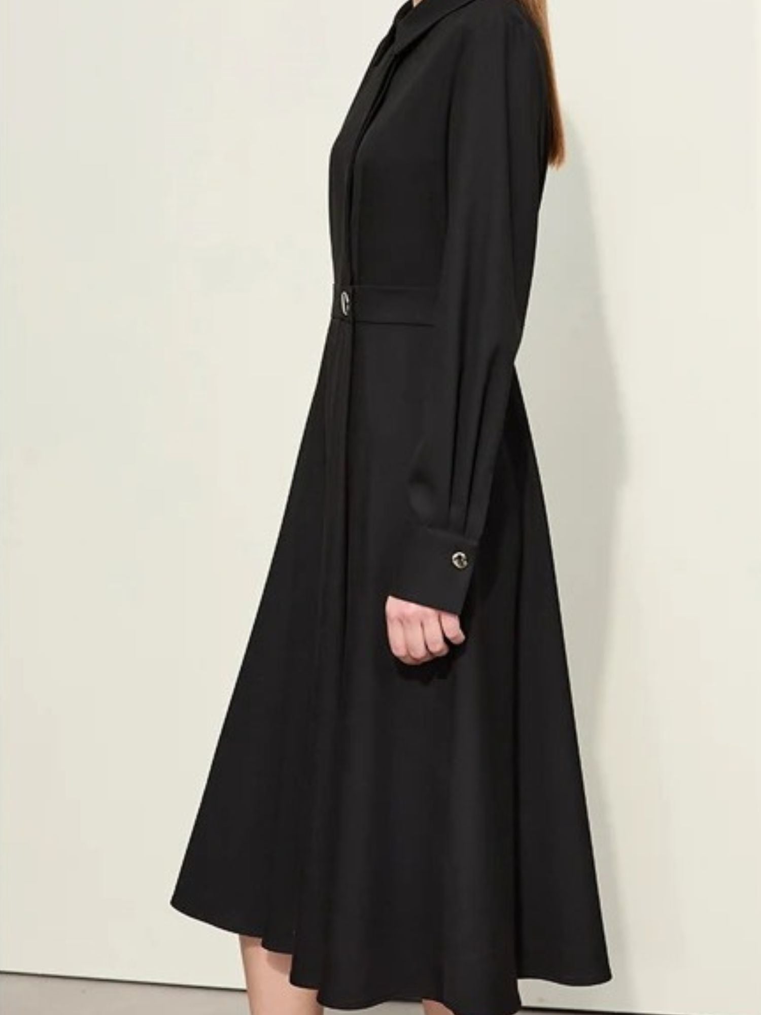 Schwarzes Midikleid mit Gürtel, Modell schräg von vorne.