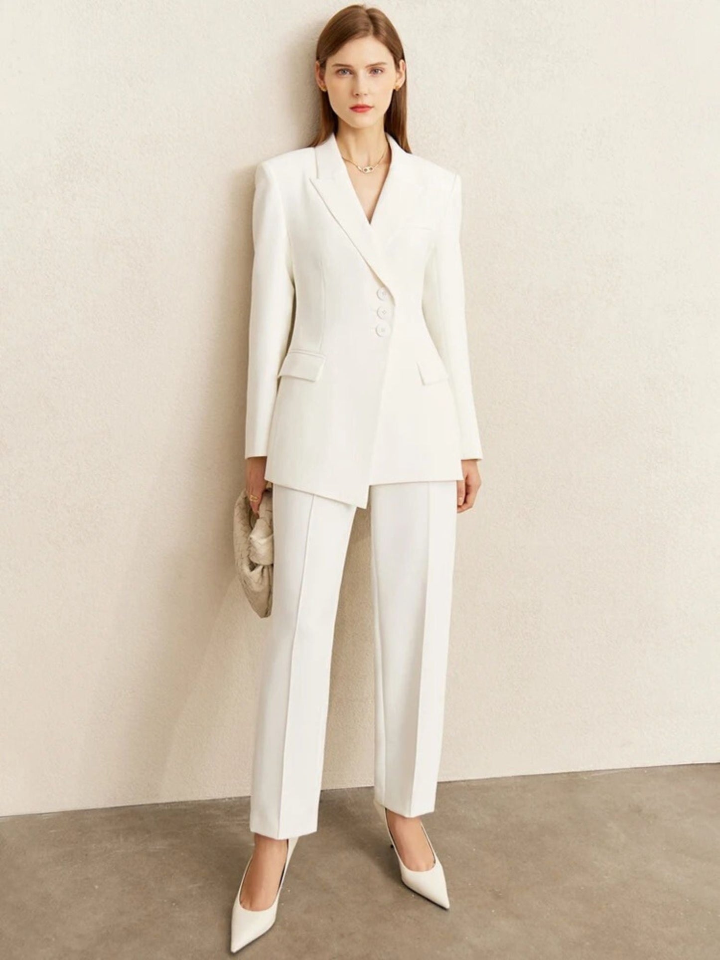 Weißer Damen-Blazer mit asymmetrischer Knopfleiste, Modell frontal stehend.
