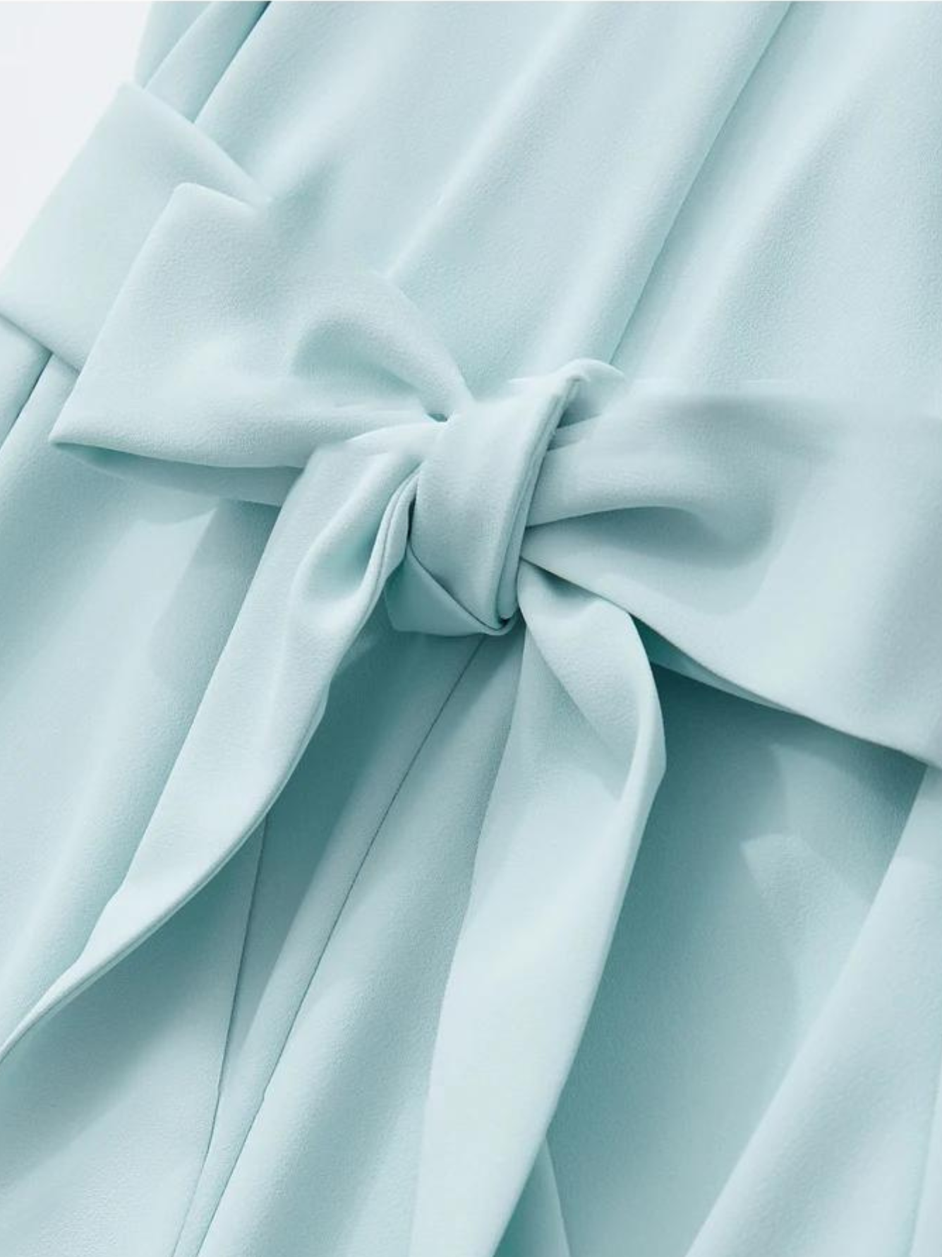 Close up of a tie design of a powder blue dress.