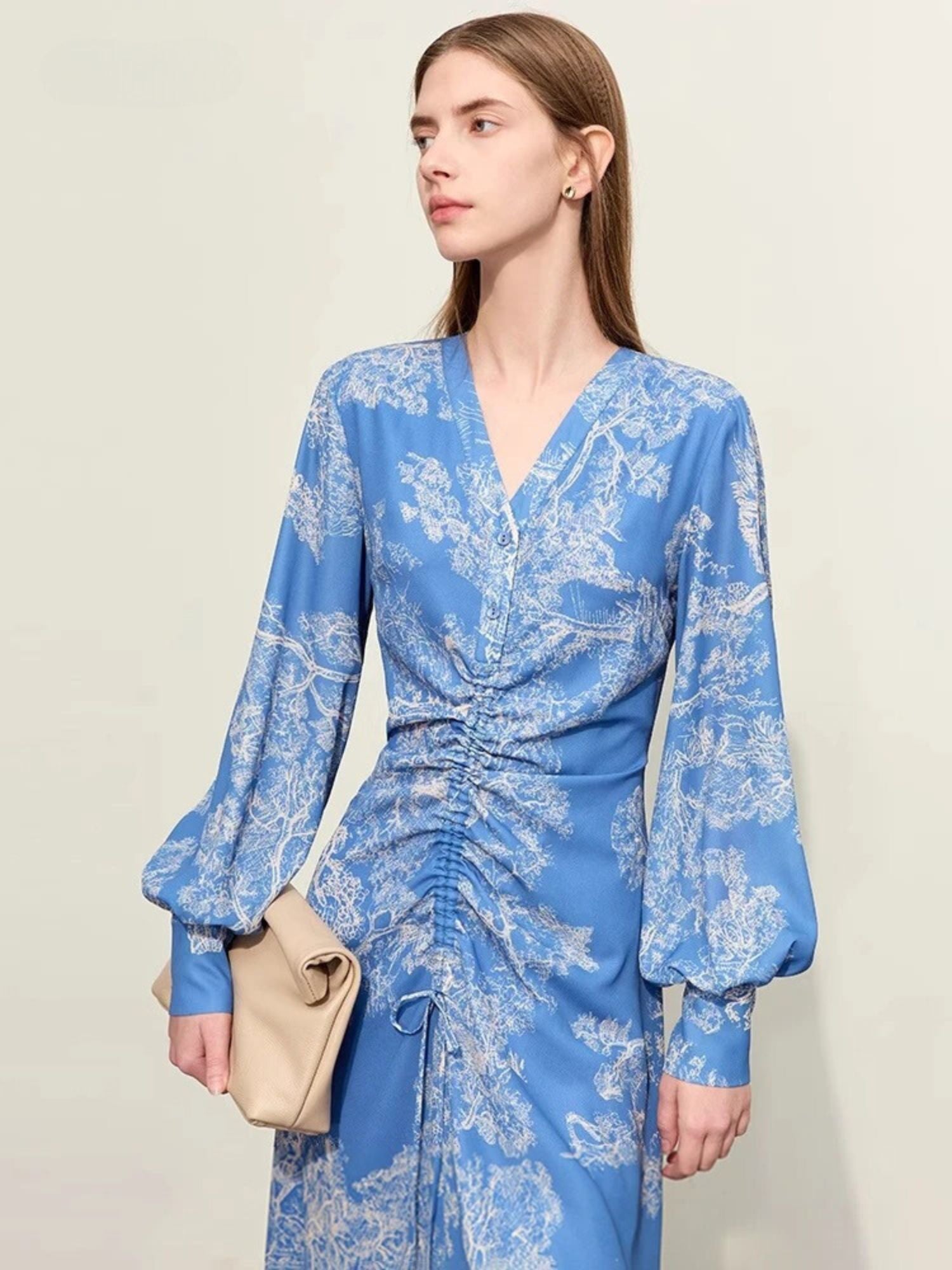 Blaues Midikleid mit Blumenmuster und Raffung, Modell frontal.