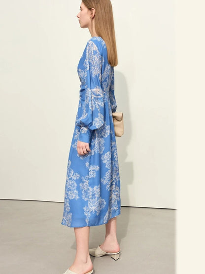 Blaues Midikleid mit Blumenmuster und V-Ausschnitt, Modell seitlich mit Tasche.