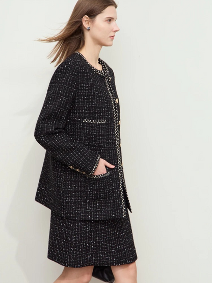 Schwarzes Tweed-Set, seitliche Ansicht, Modell mit Handtasche.

