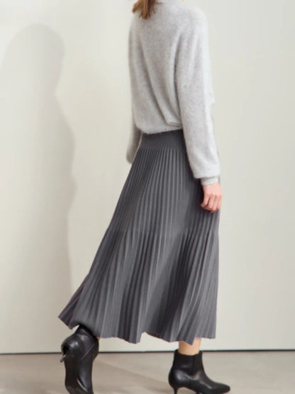 Grauer Plisseerock mit Farbkontrast, Modell frontal mit Stiefeletten.