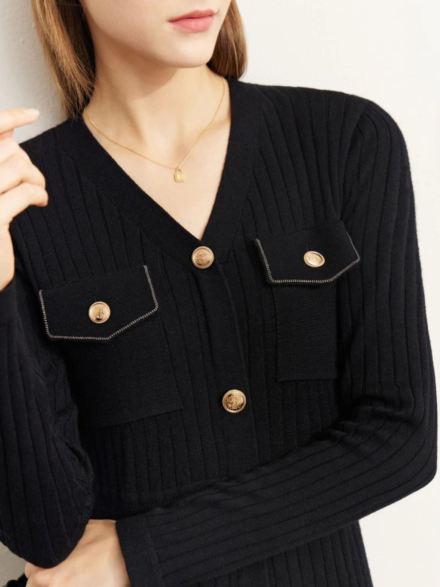 Nahaufnahme: Knopfleiste und Brusttaschen des schwarzen Strickkleids.