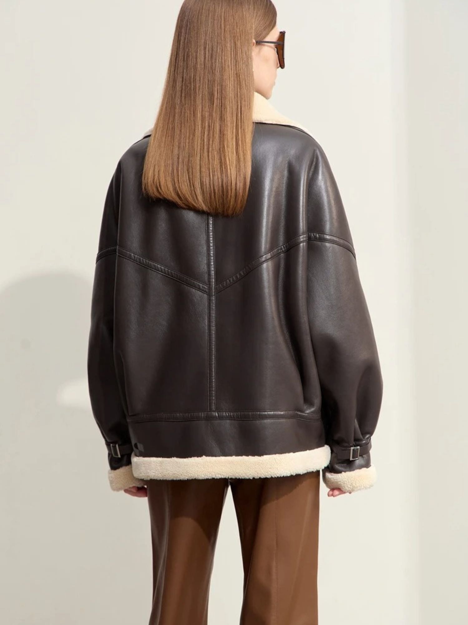 Fliegerjacke aus Lederimitat mit weitem Schnitt, Modell seitlich mit Sonnenbrille.

